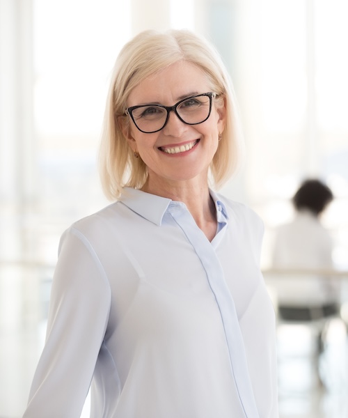 Smiling mature attractive businesswoman in glasses looking in ca Smiling mature attractive businesswoman in glasses looking in camera, happy friendly middle aged female executive, older team leader or business coach mentor posing in office, headshot portrait<br />